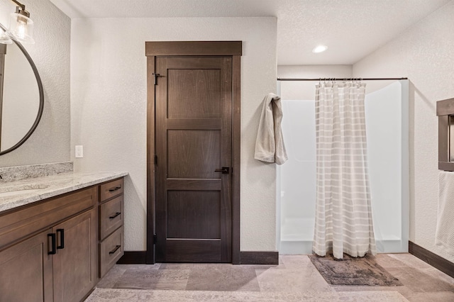 bathroom featuring vanity, a textured ceiling, and tile patterned flooring