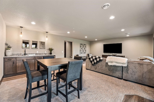 dining space with light hardwood / wood-style floors and sink