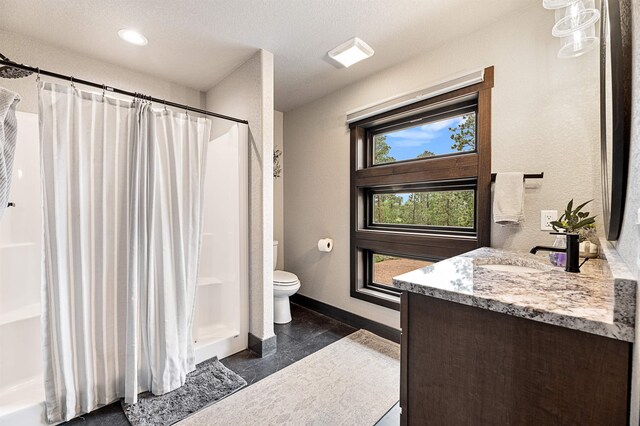 21242 Rubys Way, Lead, SD 57754 - bathroom featuring vanity, toilet, curtained shower, a textured wall, and baseboards