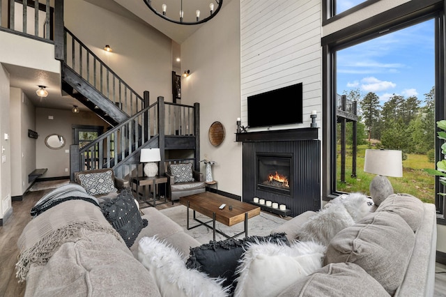 21242 Rubys Way, Lead, SD 57754 - living area with a large fireplace, a high ceiling, baseboards, and wood finished floors