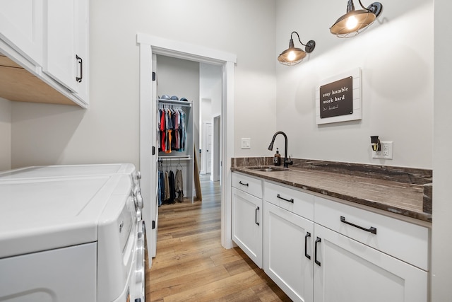 washroom featuring cabinets, separate washer and dryer, light wood-type flooring, and sink