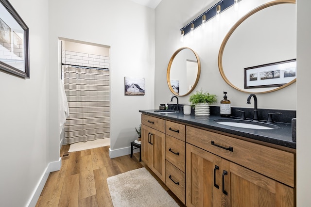 bathroom with wood-type flooring and double sink vanity