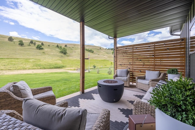 view of patio with a rural view and an outdoor living space with a fire pit