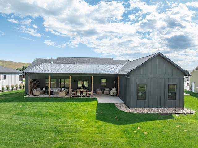 back of house with a patio area, a lawn, board and batten siding, and an outdoor hangout area