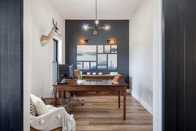 office area featuring baseboards, an inviting chandelier, and wood finished floors