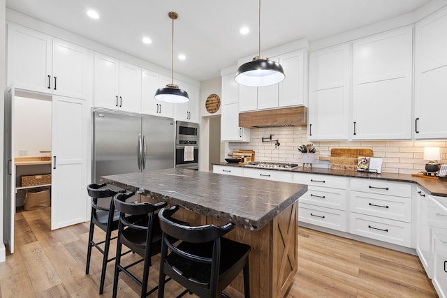 kitchen featuring under cabinet range hood, stainless steel appliances, white cabinetry, and light wood finished floors