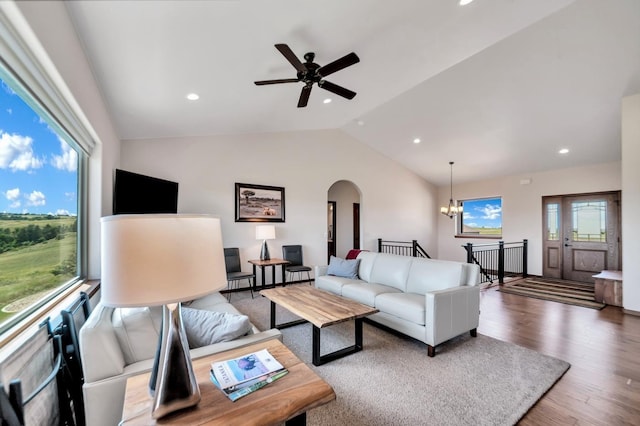 living room featuring hardwood / wood-style flooring, vaulted ceiling, and ceiling fan with notable chandelier