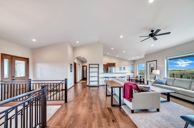 living room featuring vaulted ceiling, ceiling fan, and light wood-type flooring