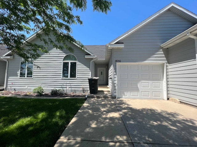 view of front of property with a garage and a front lawn