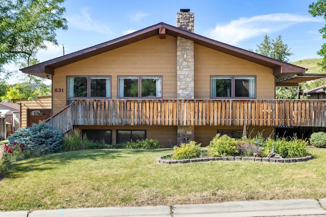 back of property with a wooden deck and a lawn