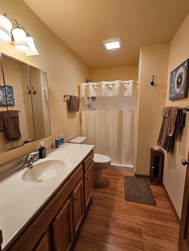 bathroom featuring vanity, wood-type flooring, and toilet