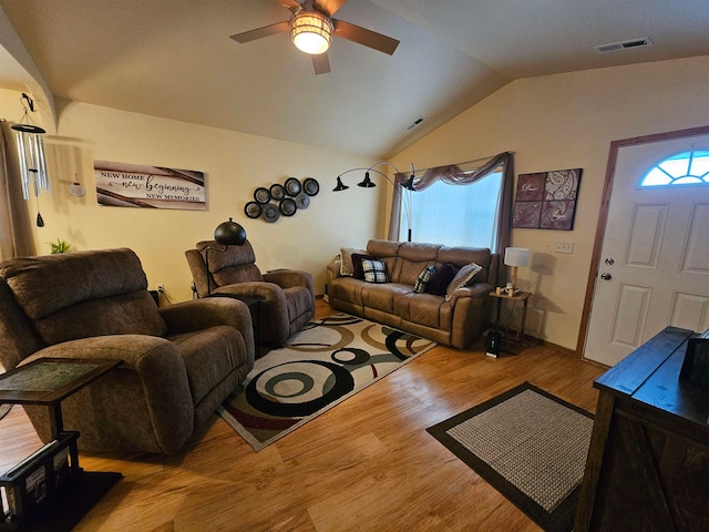 living room with lofted ceiling, wood-type flooring, and a healthy amount of sunlight