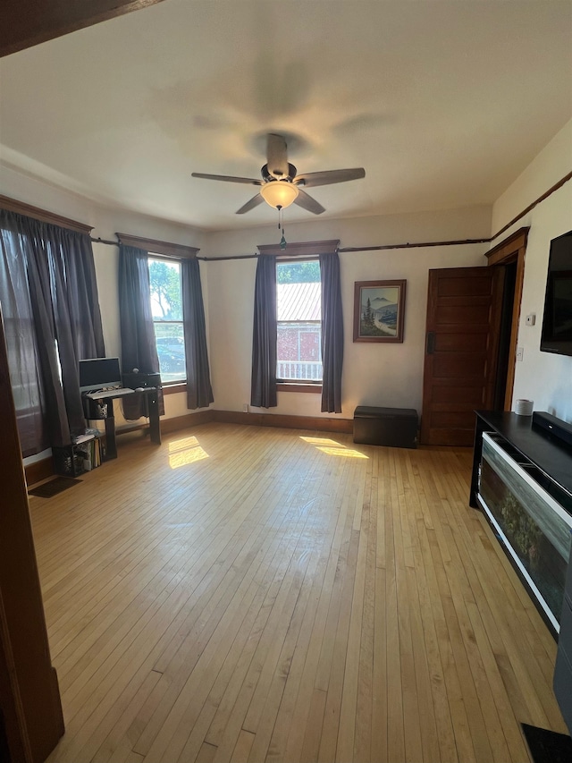 interior space with multiple windows, light hardwood / wood-style flooring, and ceiling fan