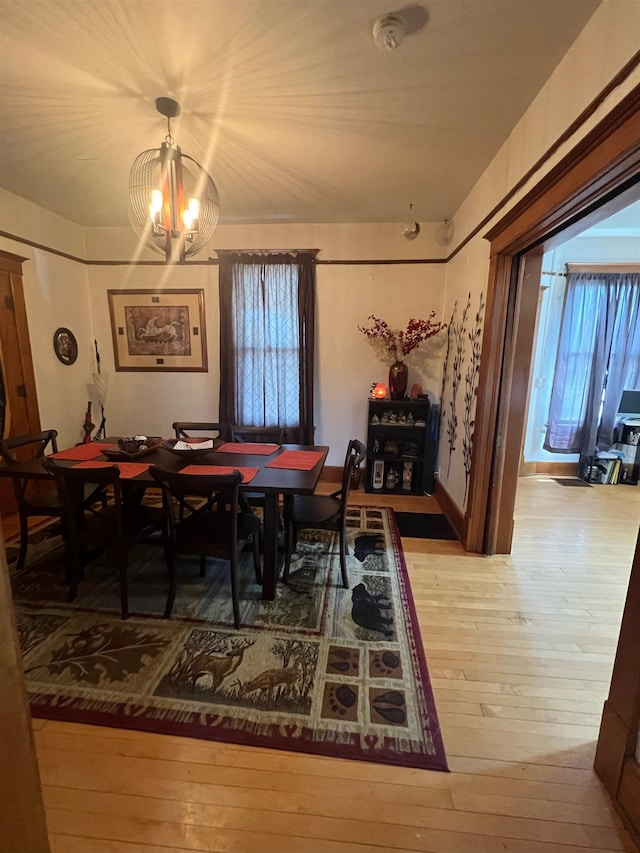 dining area with an inviting chandelier, plenty of natural light, and light wood-type flooring