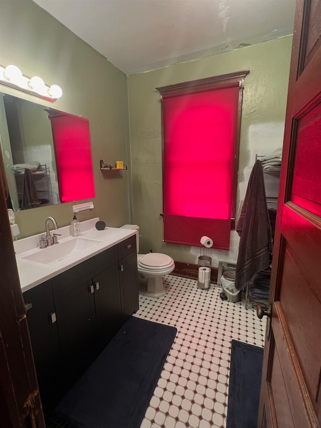 bathroom featuring tile patterned flooring, toilet, and vanity