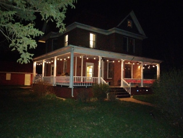 farmhouse featuring a lawn and covered porch