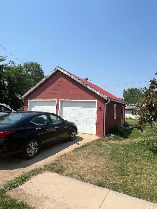 view of side of property featuring a garage and a yard