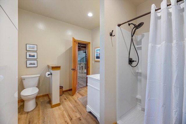 bathroom featuring vanity, toilet, hardwood / wood-style flooring, and walk in shower