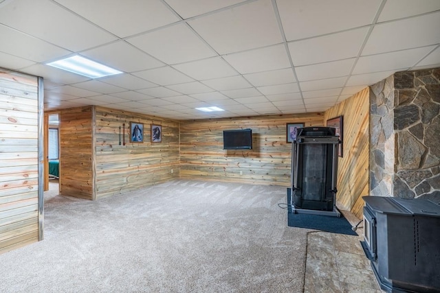 23470 Mineral Ln, Hill City, SD 57745 - basement featuring wood walls, a drop ceiling, carpet, and a wood stove