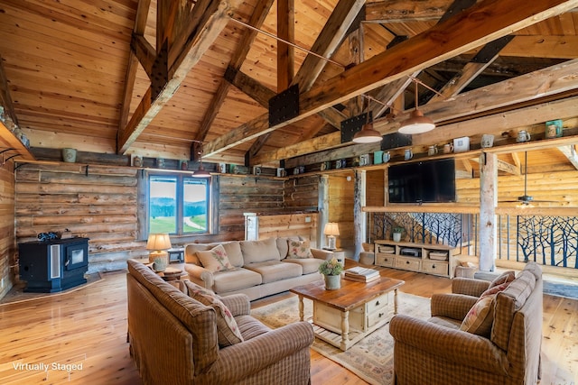23470 Mineral Ln, Hill City, SD 57745 - living room with beam ceiling, light wood-type flooring, high vaulted ceiling, and a wood stove
