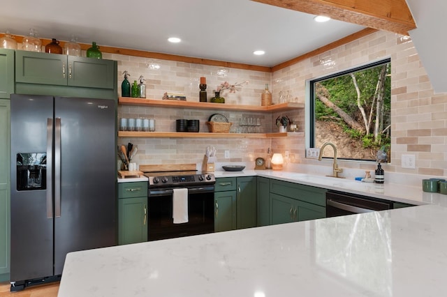 kitchen featuring sink, green cabinets, decorative backsplash, and stainless steel appliances