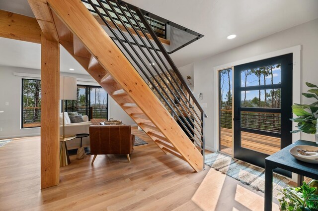 kitchen featuring light hardwood / wood-style flooring, tasteful backsplash, electric range oven, kitchen peninsula, and refrigerator with ice dispenser