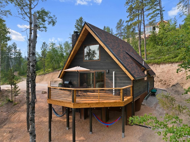 rear view of house featuring a wooden deck