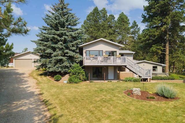 view of front facade with a garage, a wooden deck, and a front lawn