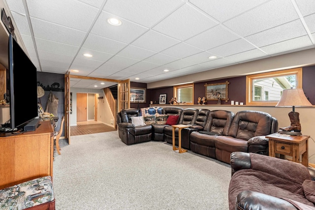 carpeted living room with a drop ceiling