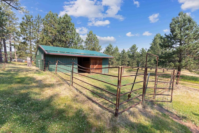 exterior space featuring an outbuilding, a lawn, and a rural view