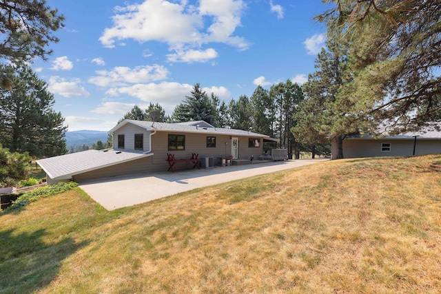 rear view of property featuring a yard and a patio area