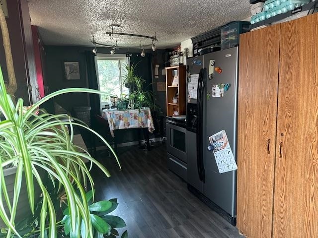 kitchen with stainless steel fridge with ice dispenser, hardwood / wood-style flooring, rail lighting, and a textured ceiling