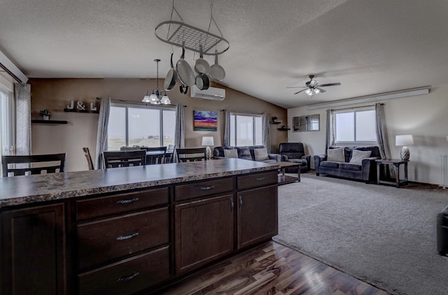 kitchen with dark carpet, dark brown cabinets, decorative light fixtures, and an AC wall unit