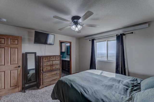 bedroom with ceiling fan, light carpet, connected bathroom, and a textured ceiling