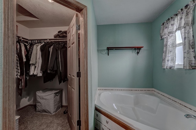 bathroom featuring a textured ceiling and a washtub