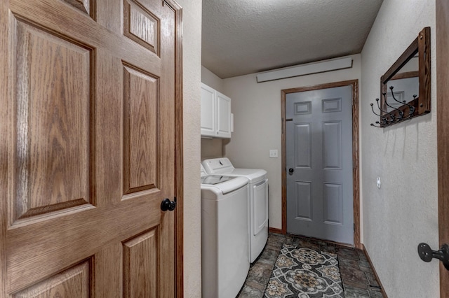 laundry room with cabinets, washer and dryer, and a textured ceiling