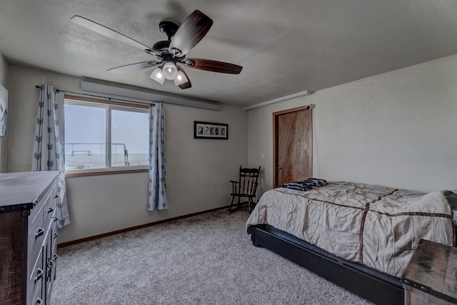 carpeted bedroom featuring ceiling fan and a textured ceiling