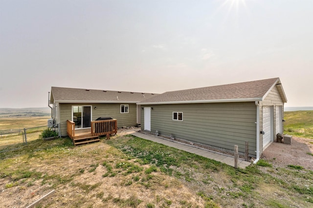 back of house featuring a garage and a deck