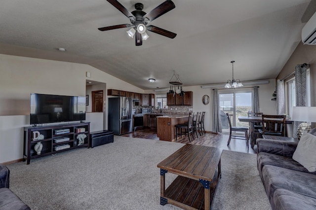 living room with ceiling fan with notable chandelier, vaulted ceiling, an AC wall unit, and dark colored carpet