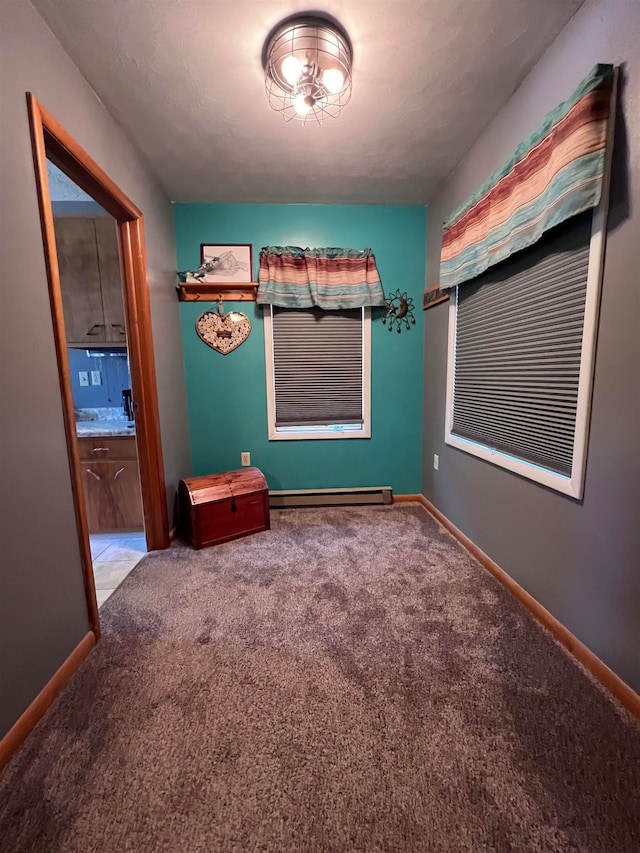 unfurnished bedroom featuring carpet flooring, a baseboard radiator, and ensuite bath