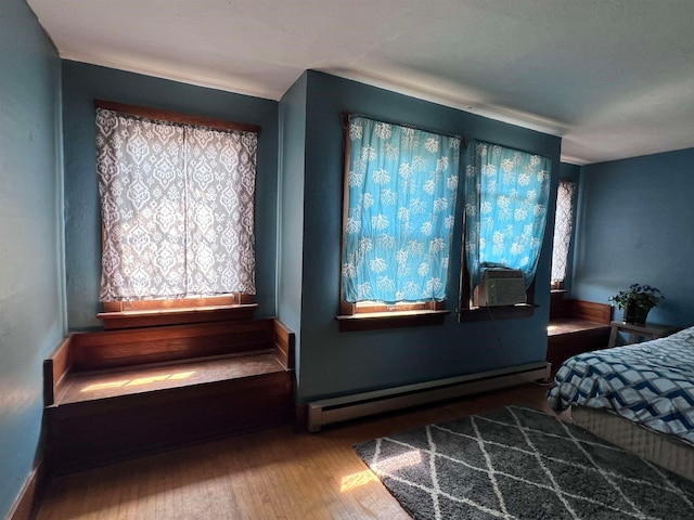 bedroom featuring hardwood / wood-style flooring, cooling unit, and a baseboard radiator