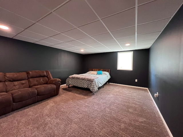 carpeted bedroom featuring a drop ceiling