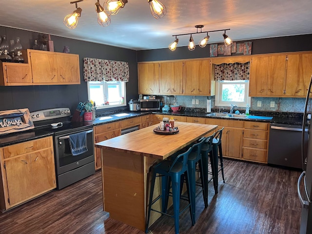 kitchen featuring butcher block countertops, a center island, stainless steel appliances, and a healthy amount of sunlight