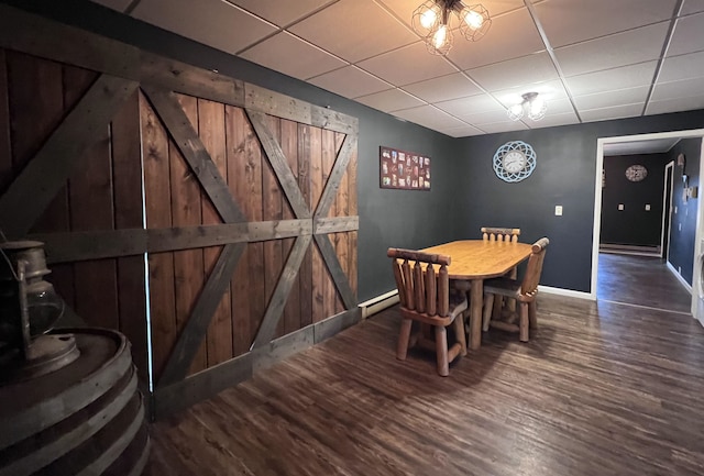 dining space featuring hardwood / wood-style flooring, a baseboard heating unit, and a paneled ceiling