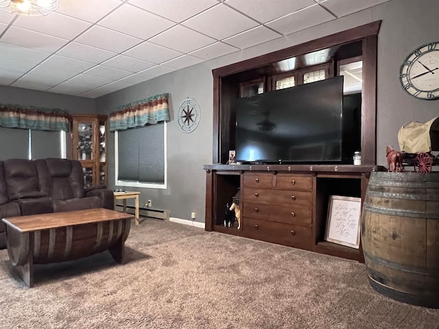 carpeted living room with a drop ceiling and baseboard heating