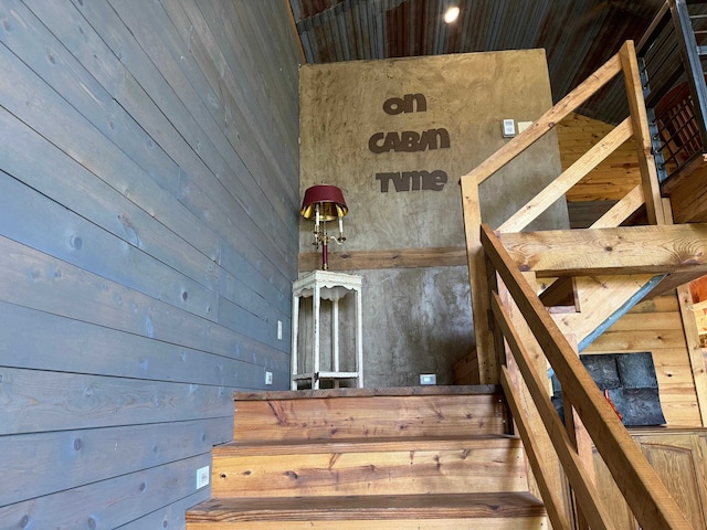 stairs featuring wood walls