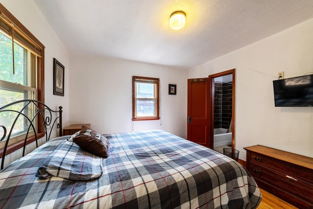 bedroom with a textured ceiling and light wood-style floors