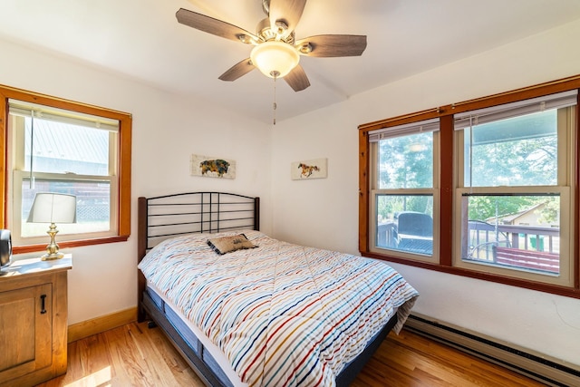 bedroom with light wood-type flooring, a baseboard radiator, baseboards, and ceiling fan