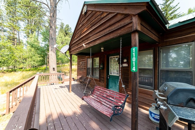 wooden deck featuring a grill