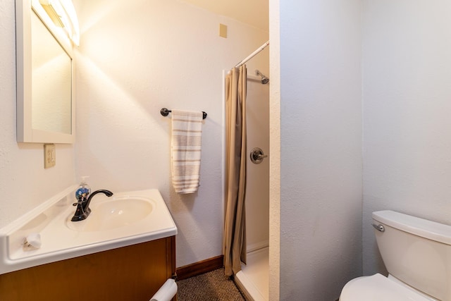 bathroom featuring baseboards, toilet, a stall shower, and vanity